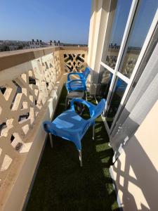 two blue chairs on a balcony with a view at Haller Park Apartments Pacific Bamburi in Mombasa