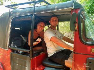 two people sitting in the back of a red van at Yala wind in Tissamaharama