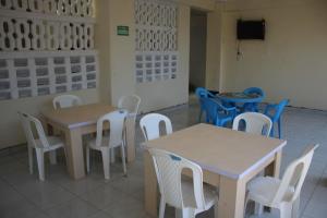 a dining room with tables and chairs and a television at Booster Villa Mtwapa in Mtwapa