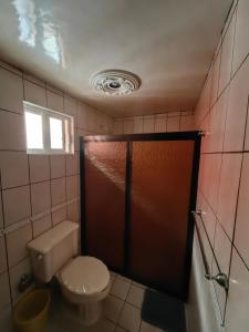 a bathroom with a toilet and a brown door at Casa Doña Ade in Xalapa