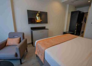 ein Schlafzimmer mit Bett, Stuhl und Fernseher in der Unterkunft Baraka Tower Hotel in Nairobi