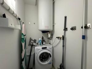 a laundry room with a washing machine in it at Appartement 3ch avec terrasse et jardin à 400m de la plage in Cavalaire-sur-Mer