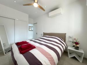 a bedroom with a large bed and a ceiling fan at Appartement 3ch avec terrasse et jardin à 400m de la plage in Cavalaire-sur-Mer