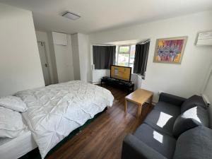 une chambre avec un lit et un canapé dans l'établissement Renfrew Road, à Hounslow 6 autres photos