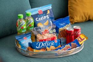 a basket filled with snacks and drinks on a couch at Luxury Apartment 60 in Warsaw