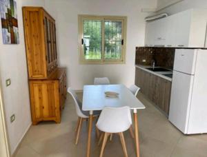 a kitchen with a table and chairs and a refrigerator at Villa Agim,Hena in Vlorë +30 photos