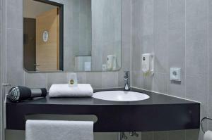 uma casa de banho com um lavatório e um espelho em B&B HOTEL Wien-St-Marx em Viena