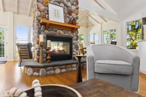 ein Wohnzimmer mit einem Steinkamin und einem Stuhl in der Unterkunft Coastal Cottage in Stevensville