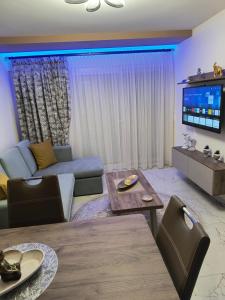 a living room with a couch and a tv at BLUE STAR Apartments #8 in Paralia Katerinis