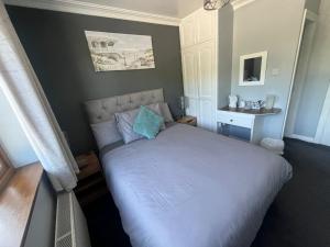 Manorlodge في ترالي: غرفة نوم بسرير كبير مع شراشف زرقاء