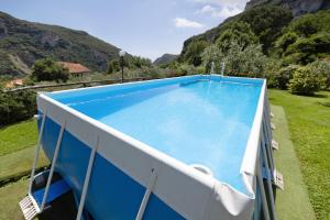 a large blue swimming pool with mountains in the background at Casa Virginia - Corbezzolo in Orco Feglino