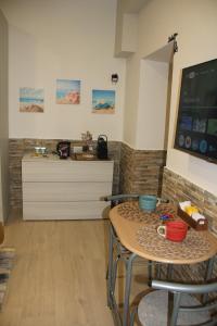 un soggiorno con un tavolo e una TV di Guesthouse Taranto Centro a Taranto