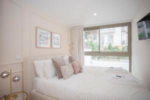 - une chambre blanche avec un lit et une fenêtre dans l'établissement Liiiving in Porto - Soho Urban Retreat, à Porto