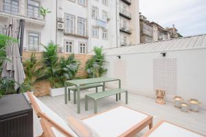 d'une terrasse avec une table et des chaises vertes sur un balcon. dans l'établissement Liiiving in Porto - Soho Urban Retreat, à Porto