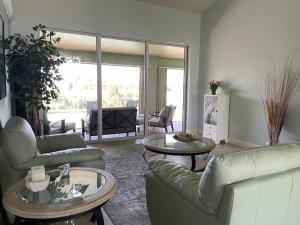 ein Wohnzimmer mit Sofas, Tischen und einem TV in der Unterkunft Relax with nature in our Waterfront 4 bedroom -HEATED POOL HOME-KING BED in Cape Coral