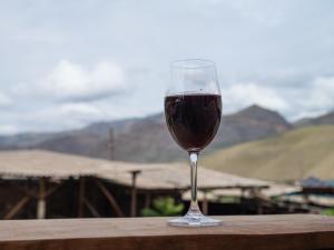 a glass of red wine sitting on a wooden table at LiViTi in Areni