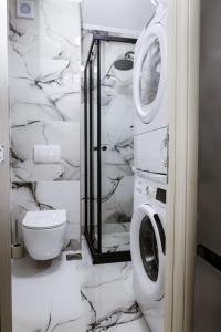 a bathroom with a toilet and a washer and dryer at City center apartment Urban Heaven in Tivat +14 photos