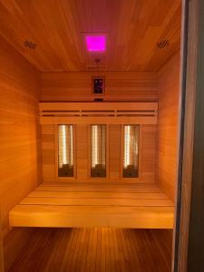 Una pequeña sauna con una luz violeta en el techo. en La maison Valban, en Veynes