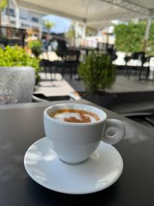 a cup of coffee sitting on a plate on a table at Villa White in Ksamil