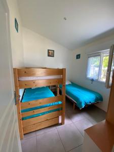 a bedroom with two bunk beds and a window at maison de lachanau in Hourtin