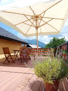 a table and chairs under an umbrella on a deck at Tree in Bled