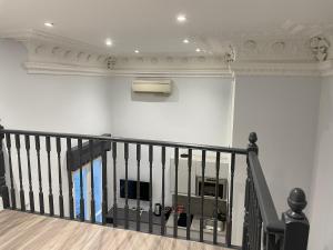 a room with a staircase with a tv on the wall at MSK Superior in London