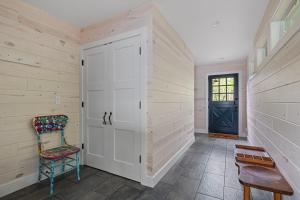 a hallway with a door and a chair and a door at Gasthaus Fox in Bridgman