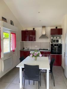 a kitchen with a white table and some chairs at maison de lachanau in Hourtin +12 photos