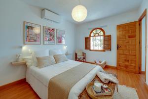Un dormitorio con una cama grande y una mesa. en Villa La Caleta - Private Pool and Garden, en Islantilla 51 fotos más