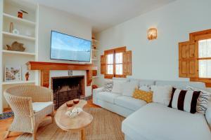Una sala de estar con un sofá blanco y una chimenea. en Villa La Caleta - Private Pool and Garden, en Islantilla