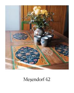a table with two plates and a vase with flowers at Casa Klein- întreaga locație in Meşendorf