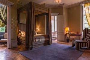 um quarto com uma cama de dossel e uma secretária em Château de Saint Paterne em Saint-Paterne