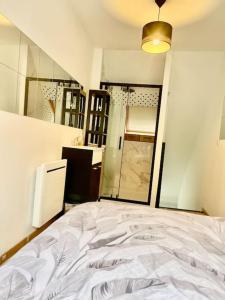 een slaapkamer met een wit bed en een spiegel bij Près de l aéroport Orly Parking gratuit in Villeneuve-le-Roi