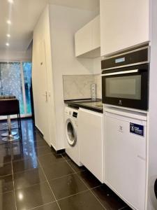 een keuken met een fornuis, een wasmachine en een droger bij Près de l aéroport Orly Parking gratuit in Villeneuve-le-Roi