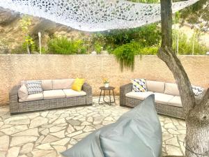 a patio with two couches and a tree at Villa Florence in Cavalaire-sur-Mer