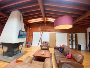 sala de estar con sofá y chimenea en Kaoglen-GrandSuite-Hot Tub-Pitlochry-Dunkeld-Pet Friendly en Balnald