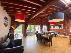 uma sala de estar com mesa e cadeiras em Kaoglen-GrandSuite-Hot Tub-Pitlochry-Dunkeld-Pet Friendly em Balnald