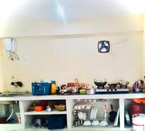 eine voll ausgestattete Küche mit einer Arbeitsplatte und einem Regal in der Unterkunft KAUSHALYADHAM MUNSYARI in Munsyari