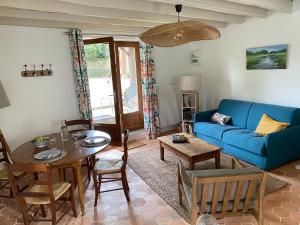 a living room with a blue couch and a table at Maison de charme, Maison carrée in Joyeux