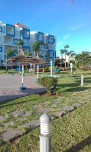 a park with palm trees and a building in the background at Kariat Cabo resort in M'diq