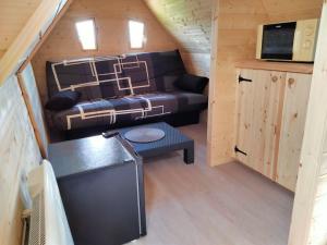 a living room with a couch in a tiny house at Cabane - La Forest in Épuisay