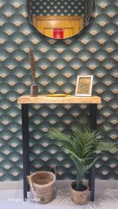 a table and a plant in a room with a wall at Apartamento Parquemar in La Mata