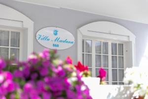 znak dla restauracji z różowymi kwiatami na pierwszym planie w obiekcie B&B Villa Madana w Rimini