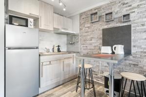 una cucina con frigorifero e tavolo con sgabelli di WELCS ESTUDIO 156 PDA en el centro a Platja  d'Aro