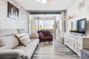 un soggiorno con un divano e una TV di WELCS ESTUDIO 156 PDA en el centro a Platja  d'Aro