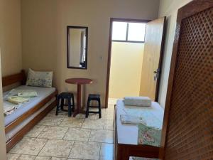 um quarto com uma cama, uma mesa e cadeiras em Pousada o Pelicano Ingleses em Florianópolis