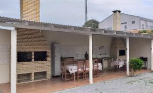 um pátio exterior com uma mesa e cadeiras em Pousada o Pelicano Ingleses em Florianópolis mais 1 fotografia