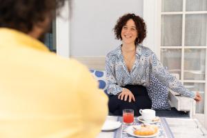een vrouw aan een tafel die met een man praat bij B&B Villa Madana in Rimini