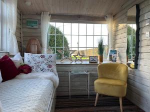 ein Schlafzimmer mit einem Bett, einem Stuhl und einem Fenster in der Unterkunft Adorable Cabin in the Countryside in Portlaoise