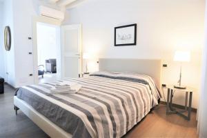 a white bedroom with a bed and a table at Stylish apartment 100 meters from San Marco square in Venice